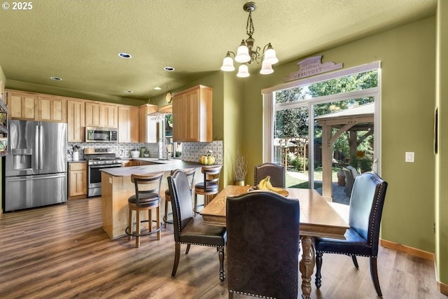 dining area with baseboards, a chandelier, and dark wood-type flooring