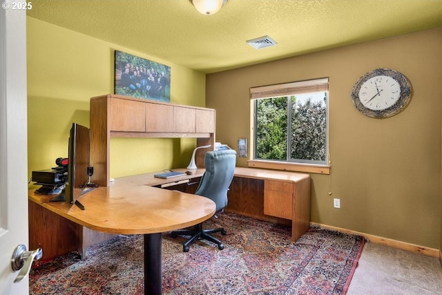 carpeted office with visible vents, a textured ceiling, and baseboards