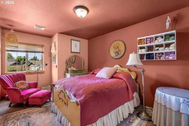 bedroom with visible vents, a textured ceiling, and carpet flooring