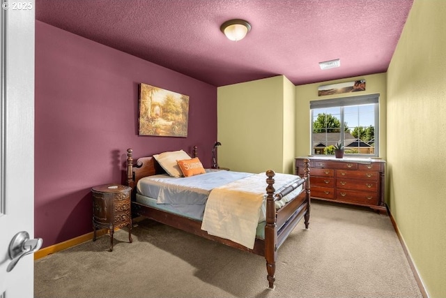 bedroom with light carpet, visible vents, baseboards, and a textured ceiling