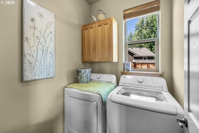 washroom featuring cabinet space and independent washer and dryer