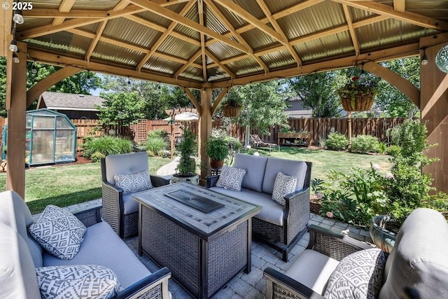 view of patio / terrace with an exterior structure, a gazebo, a fenced backyard, an outdoor structure, and an outdoor living space