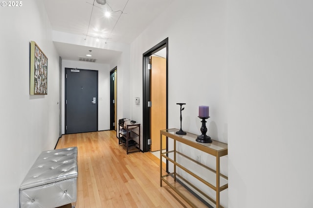 interior space with rail lighting, visible vents, and light wood finished floors