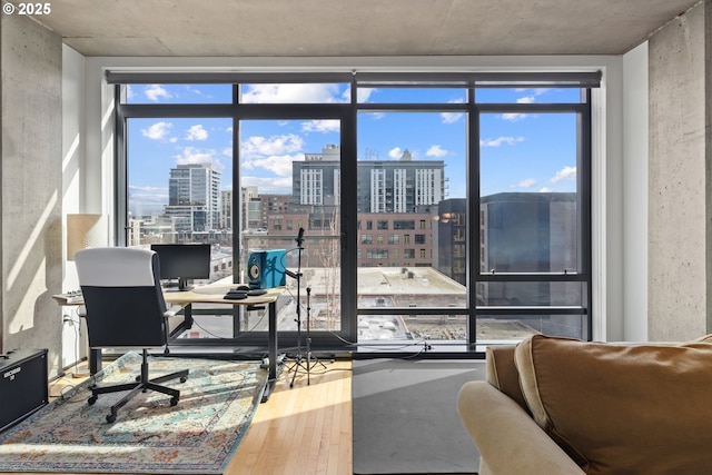 office space with expansive windows and wood finished floors