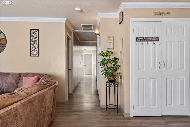 corridor featuring wood-type flooring, crown molding, and a textured ceiling