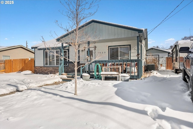 snow covered property featuring covered porch and central air condition unit