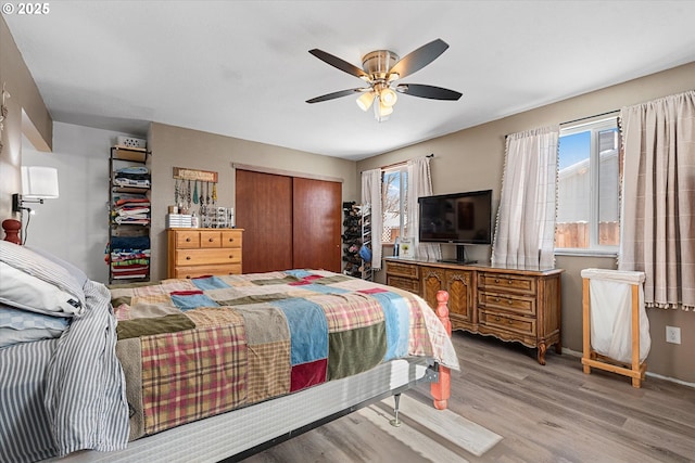 bedroom with ceiling fan, light hardwood / wood-style floors, and a closet