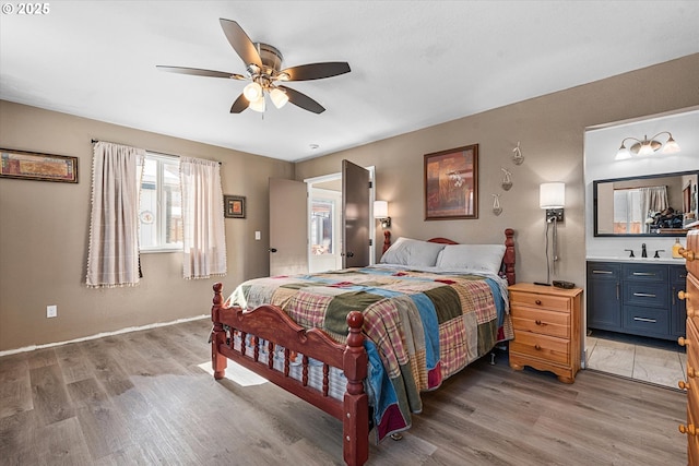 bedroom with sink, hardwood / wood-style flooring, connected bathroom, and ceiling fan