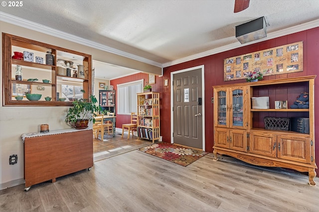 entryway featuring crown molding, wood-type flooring, and a textured ceiling