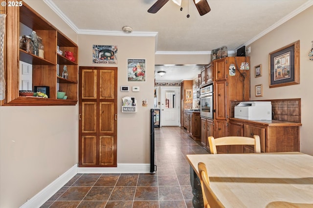 dining space featuring ceiling fan, crown molding, and dark tile patterned floors