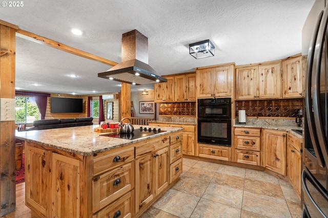 73594 Davis Ln, Pendleton, OR 97801 - kitchen with black appliances, island exhaust hood, a center island, light stone counters, and recessed lighting
