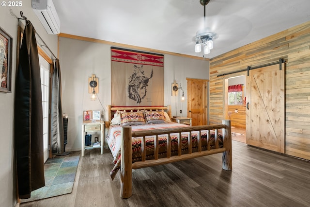 73594 Davis Ln, Pendleton, OR 97801 - bedroom featuring a wall unit AC, wood walls, a barn door, wood finished floors, and ensuite bathroom