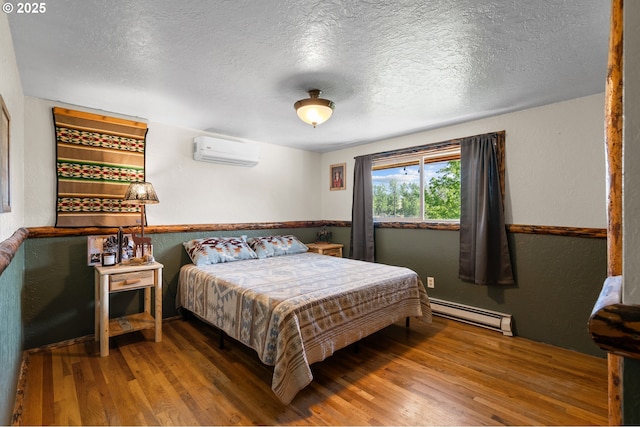 73594 Davis Ln, Pendleton, OR 97801 - bedroom featuring an AC wall unit, baseboard heating, wood finished floors, and a textured ceiling