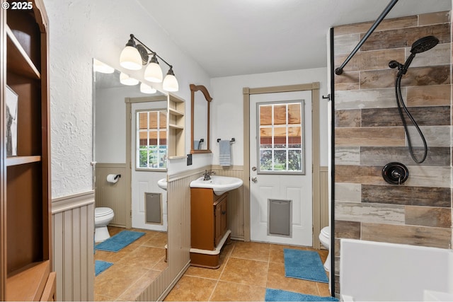 73594 Davis Ln, Pendleton, OR 97801 - bathroom with toilet, vanity, a wainscoted wall, tiled shower, and tile patterned floors