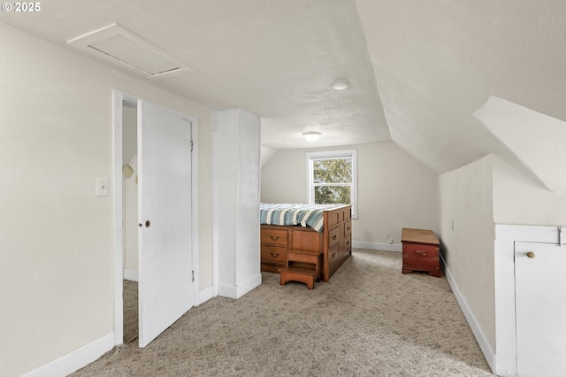 bedroom featuring vaulted ceiling, a textured ceiling, baseboards, and light colored carpet