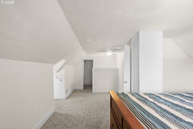 bedroom featuring lofted ceiling, baseboards, a textured ceiling, and light colored carpet