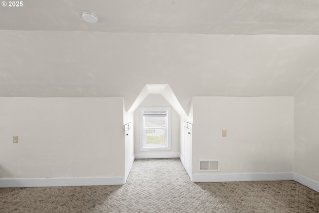 bonus room with lofted ceiling, baseboards, light carpet, and visible vents