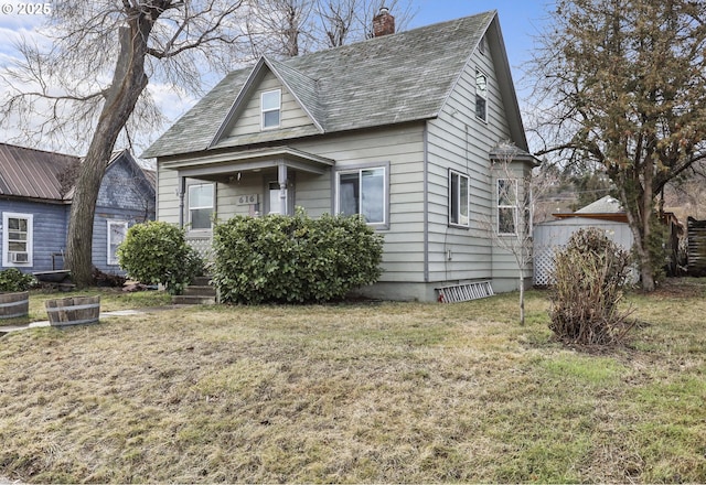 bungalow-style house featuring a chimney and a front lawn