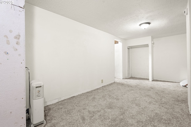 empty room with light carpet and a textured ceiling