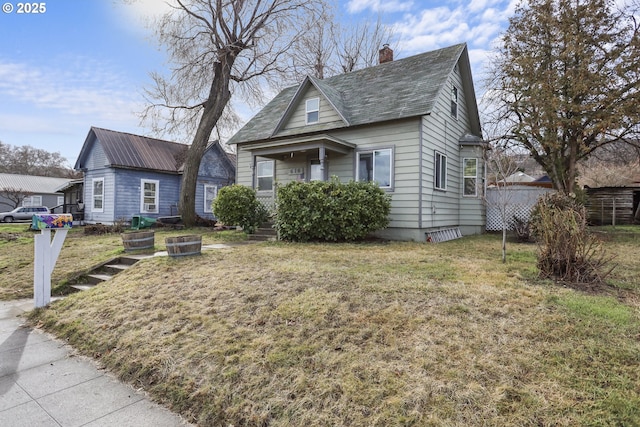 bungalow-style house featuring a front lawn and a chimney