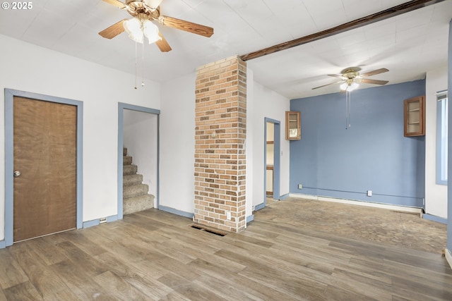 unfurnished living room with visible vents, baseboards, a ceiling fan, stairway, and light wood finished floors