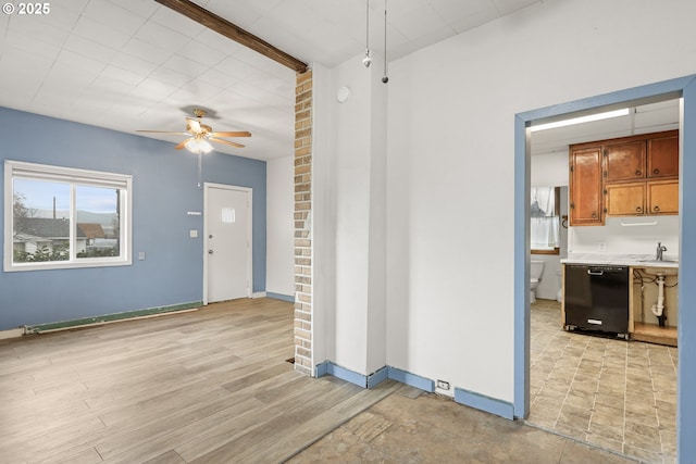 spare room with a ceiling fan, baseboards, light wood-style floors, and a sink