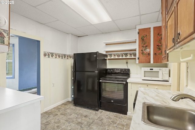 kitchen with a sink, black appliances, light countertops, and brown cabinets