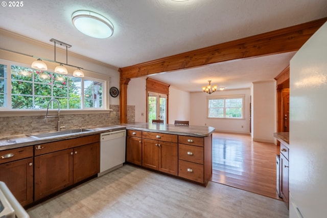 kitchen featuring a peninsula, a sink, beamed ceiling, dishwasher, and brown cabinetry