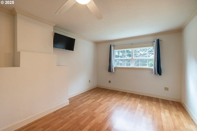 spare room featuring ceiling fan, ornamental molding, wood finished floors, and baseboards