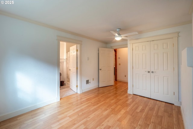 unfurnished bedroom with ceiling fan, baseboards, light wood-style floors, a closet, and crown molding