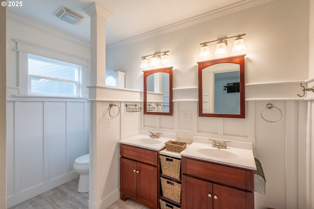 full bathroom with two vanities, visible vents, a sink, and a decorative wall