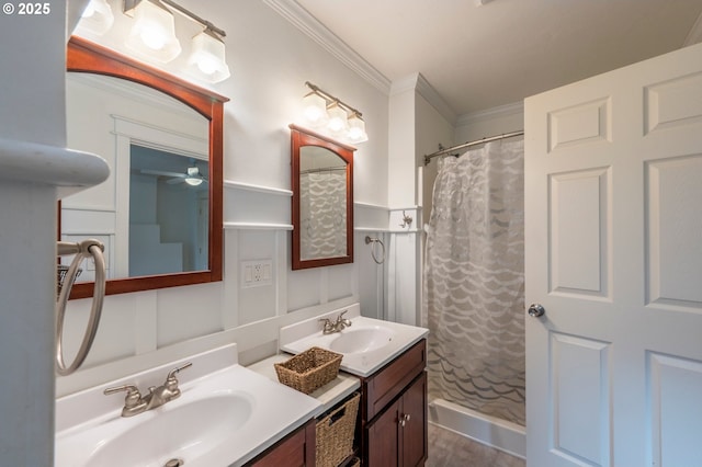 bathroom featuring a wainscoted wall, crown molding, a decorative wall, a shower with shower curtain, and vanity