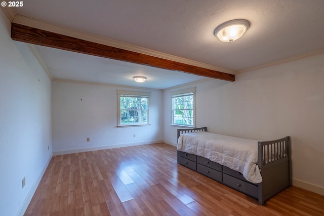 unfurnished bedroom with crown molding, baseboards, and wood finished floors