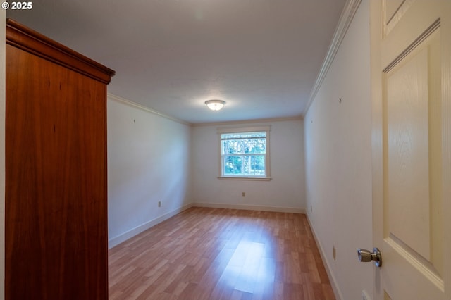 interior space with baseboards, crown molding, and light wood finished floors