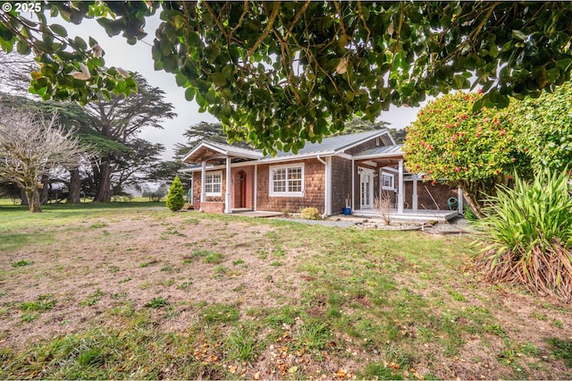 view of front of house featuring metal roof and a front lawn