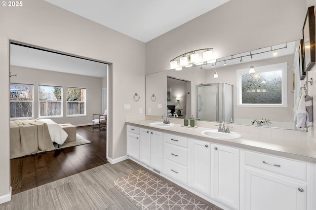 bathroom with vanity, a shower with shower door, and hardwood / wood-style floors