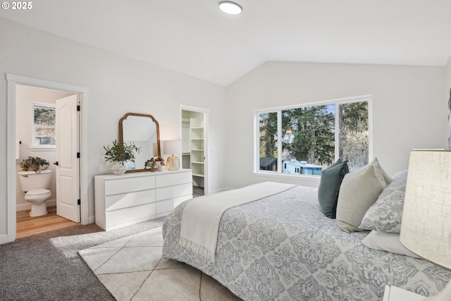 bedroom featuring lofted ceiling, carpet flooring, a spacious closet, ensuite bath, and a closet