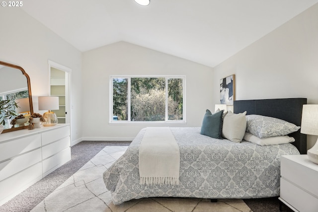 carpeted bedroom with lofted ceiling