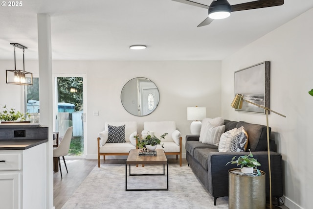 living room featuring ceiling fan and light hardwood / wood-style floors