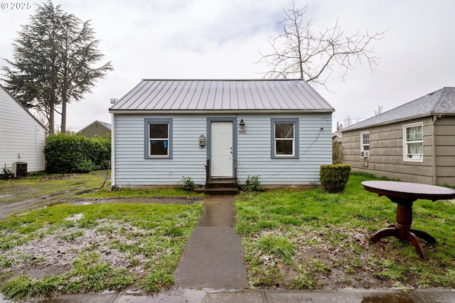 bungalow-style house featuring entry steps, cooling unit, and metal roof