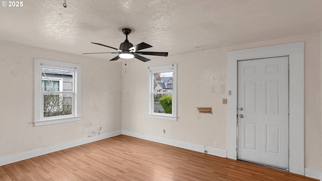 entrance foyer with baseboards, a healthy amount of sunlight, a ceiling fan, and light wood finished floors