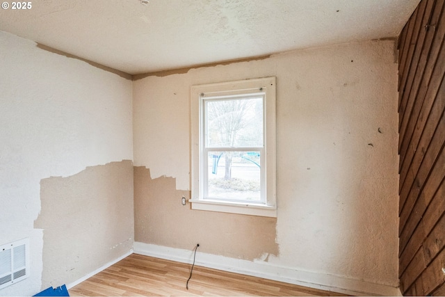 unfurnished room featuring baseboards, visible vents, and light wood finished floors