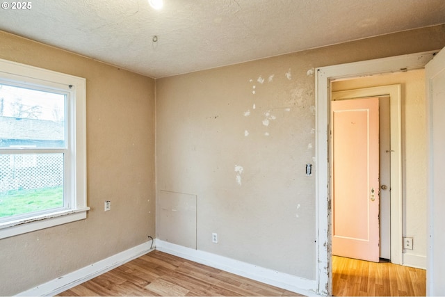 empty room with baseboards and light wood-style floors