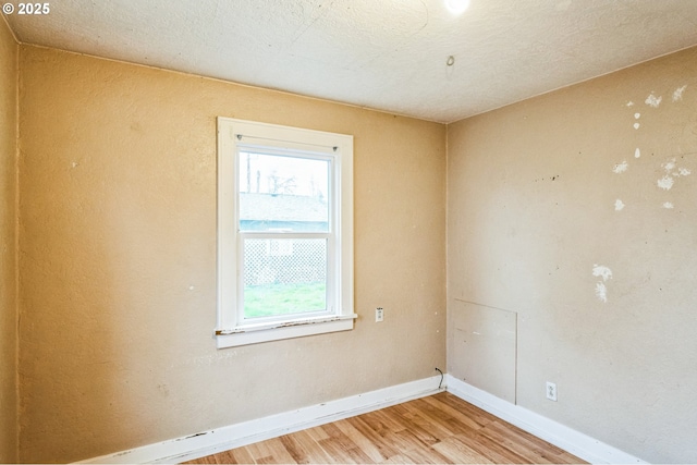 spare room featuring light wood-type flooring and baseboards