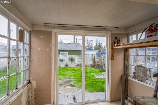 doorway with wood ceiling and a textured wall