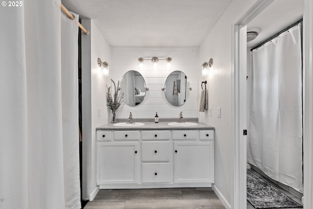 222 NE Darcie Way, Myrtle Creek, OR 97457 - bathroom with double vanity, wood finished floors, a shower with shower curtain, and baseboards