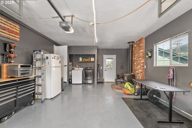 222 NE Darcie Way, Myrtle Creek, OR 97457 - garage featuring freestanding refrigerator, a wood stove, a garage door opener, and independent washer and dryer
