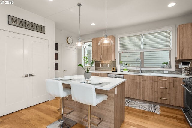 kitchen featuring a sink, decorative backsplash, a kitchen bar, and light countertops