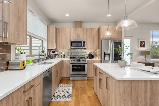kitchen featuring a sink, modern cabinets, light brown cabinets, and stainless steel appliances