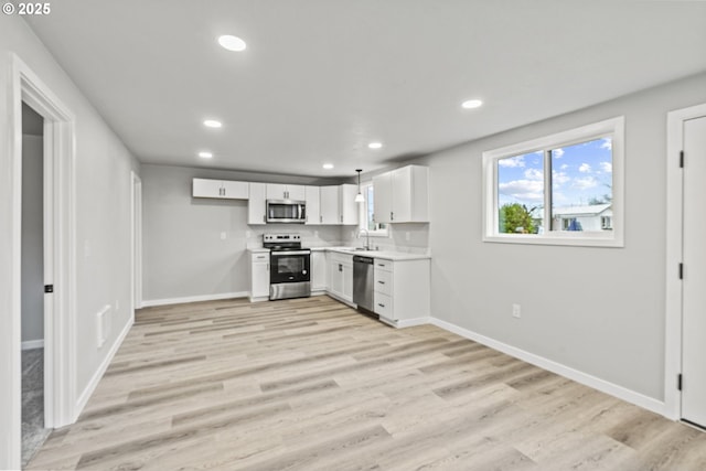 kitchen with light hardwood / wood-style floors, sink, white cabinets, and stainless steel appliances